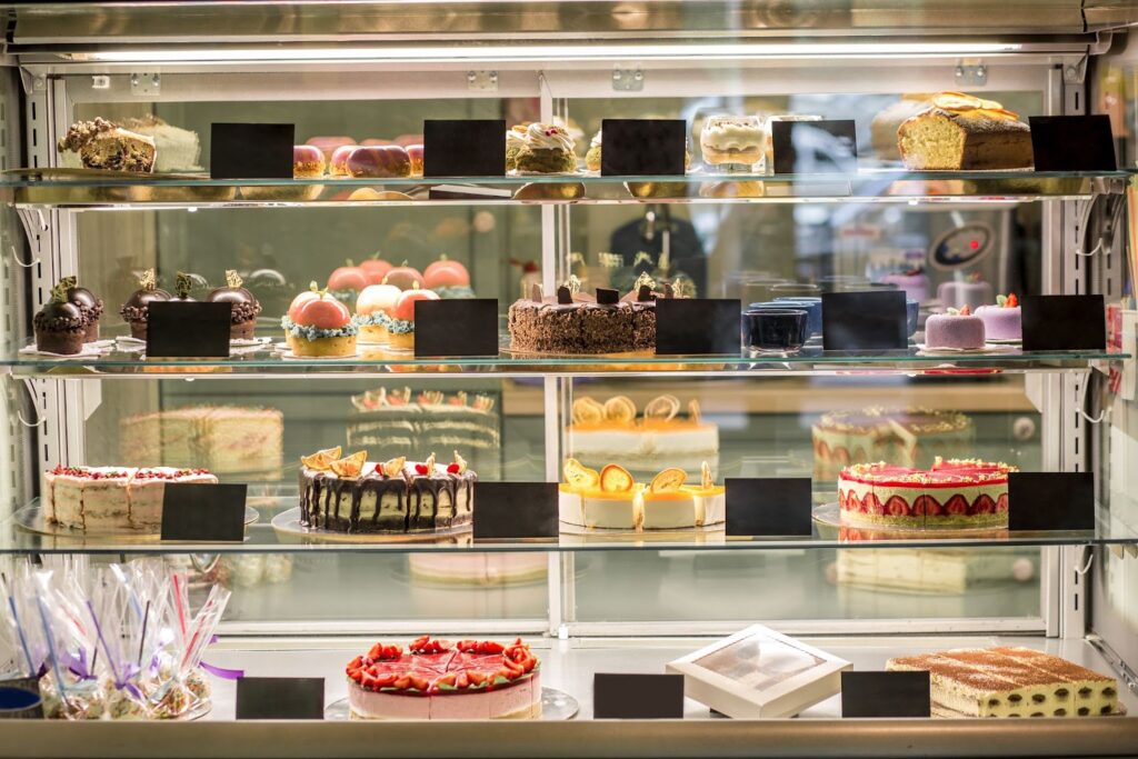 a glass showcase in a pastry shop with a variety of fresh cakes and pastries