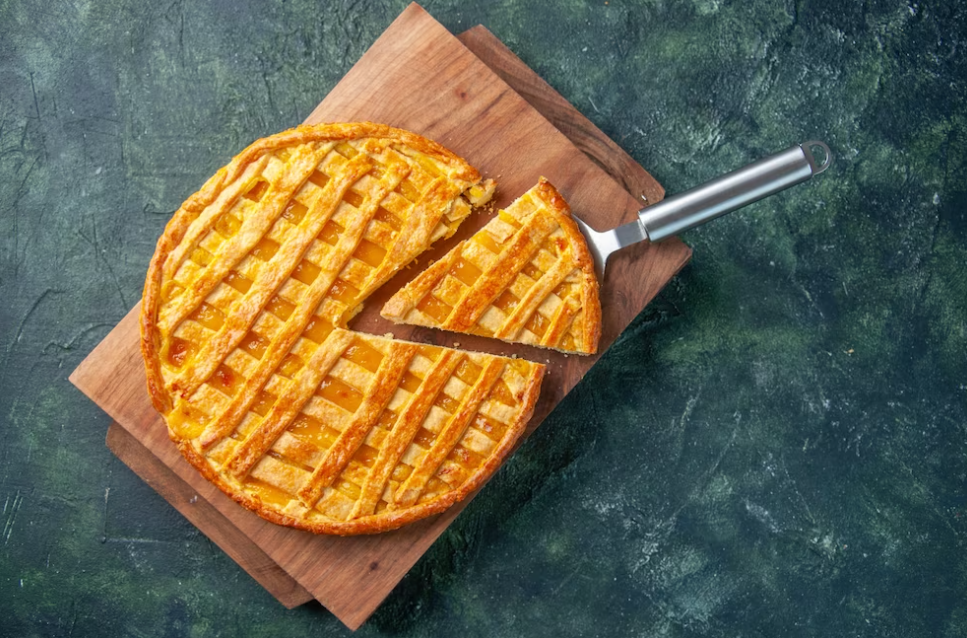 Top view of apple pie with sliced one piece on a green marble table