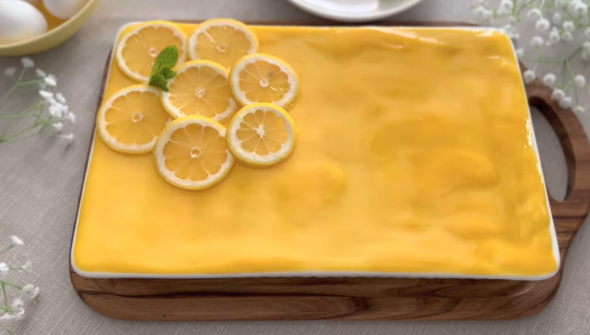 lemon tiramisu decorated with a slice of lemons on a wooden desk