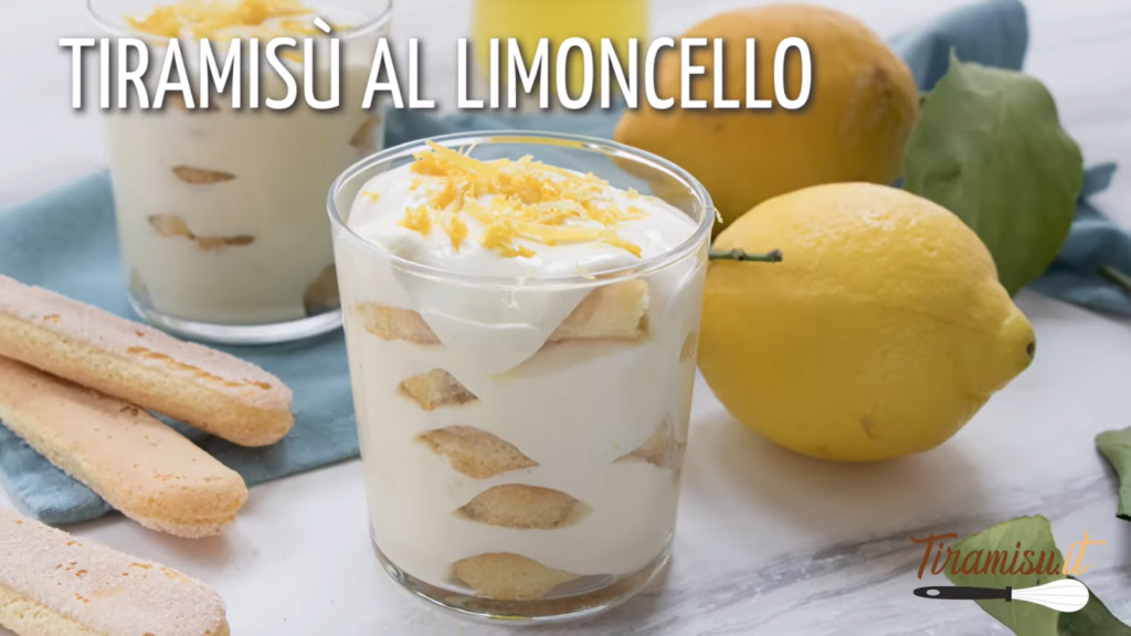 tiramisu limoncello in a glass, lemons, and ladyfingers on the table