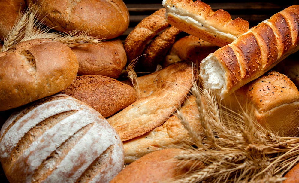 Assorted bread varieties with wheat on the sides